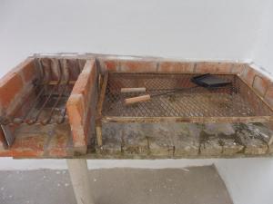 a brick grill with two cigars and a cell phone on it at El descanso in Las Toninas