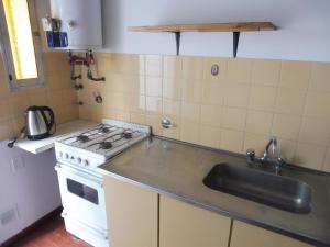 a kitchen with a stove and a sink at El descanso in Las Toninas +6 photos