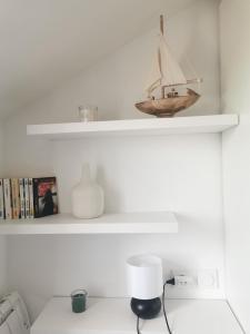 a shelf with a wooden sail boat on it at CŒUR DE VILLE - studio charme et confort in Vannes