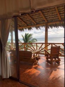 a patio with chairs and a view of the ocean at Seaside Garden Ecolodge Mompiche in Mompiche