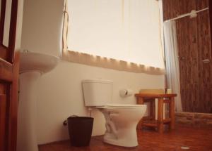 a bathroom with a white toilet and a window at Seaside Garden Ecolodge Mompiche in Mompiche