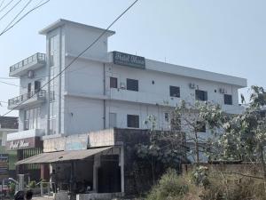 a large white building with a sign on it at The Hotel Moon in Pāonta Sāhib +3 photos