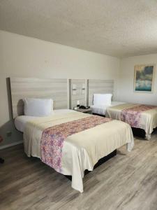 ein Hotelzimmer mit zwei Betten in einem Zimmer in der Unterkunft Discovery Inn Lafayette in Lafayette