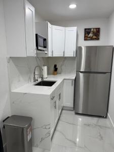 a kitchen with white cabinets and a stainless steel refrigerator at Apartment in Tampa