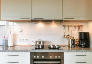 eine Küche mit 2 Töpfen und Pfannen auf einem Herd in der Unterkunft Maisonette Apartment In Historic Paretz in Paretz