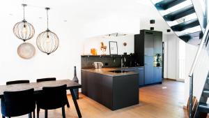 a kitchen with a dining table and a kitchen with blue cabinets at COSMOPOLITAN APARTMENTS Zürich Seefeld in Zürich