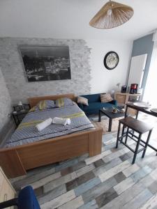 une chambre avec un lit et un canapé bleu dans l'établissement Studio Fontaine, à Niort