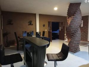 een kamer met een tafel en stoelen en een bakstenen muur bij Casa Terral 