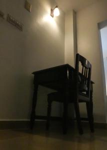 a wooden table and a chair in a room at Casa Linda in Cochin