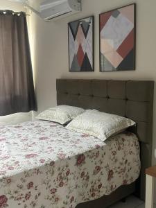 a bed in a bedroom with two pictures on the wall at Sitio Encantos do Vale in Major