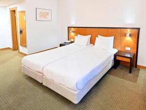 a large white bed in a hotel room at Hotel Bagoeira in Barcelos +46 photos