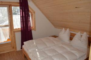 a white bed in a room with a window at "Das Jagdhaus"- Chalet am Skigebiet mit Sauna in Philippsreut