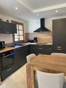 a kitchen with a wooden table and a counter top at Duplex Haut de Gamme neuf - 10 personnes - App 004 in Saint-Sorlin-dʼArves +21 photos