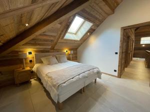 a bedroom with a large bed in a attic at Duplex Haut de Gamme neuf - 10 personnes - App 004 in Saint-Sorlin-dʼArves