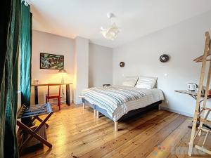 a bedroom with a bed and a wooden floor at Anavel Atao in Lille +3 photos