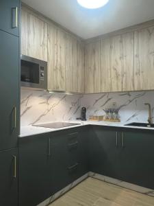 a kitchen with black cabinets and white counter tops at Apartamento Boutique Centro Histórico in Antequera
