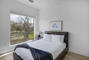 a bedroom with a large bed and a window at Landing Apartments - Denton in Denton