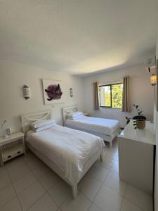 a bedroom with two beds and a window at Casa Julio in Carvoeiro +20 photos