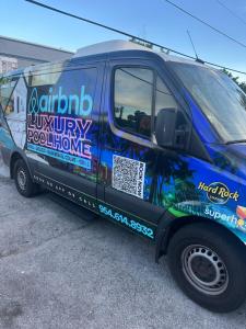 a van parked in a parking lot with a sign on it at Guest house 7 mins From stadium in Opa-locka