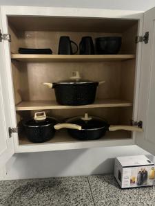 a cupboard with pots and pans sitting in it at Guest house 7 mins From stadium in Opa-locka