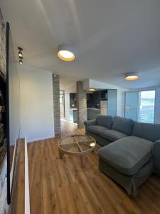 a living room with a blue couch and a glass table at לוריא יוקרה בעתיקה in Safed