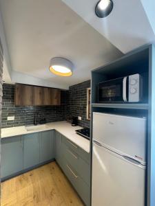 a kitchen with a white refrigerator and a microwave at לוריא יוקרה בעתיקה in Safed