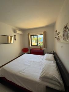 a bedroom with a large white bed with a red chair at Casa Julio in Carvoeiro