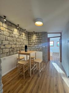 a dining room with a stone wall and a table and chairs at לוריא יוקרה בעתיקה in Safed