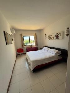 a bedroom with a bed and a red chair at Casa Julio in Carvoeiro