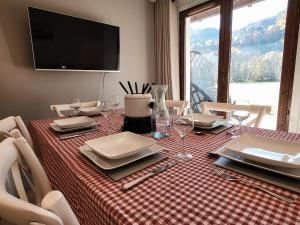 a dining room table with a red and white checkered table cloth at Cascades, 3 bedroom chalet with shared pool. in Samoëns