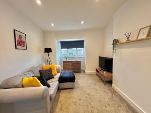 ein Wohnzimmer mit Sofa und Fernseher in der Unterkunft Central Apartment - 16 Mins to London in Potters Bar