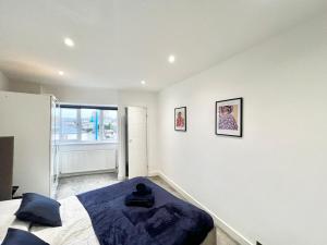 ein weißes Schlafzimmer mit einem Bett und einem Fenster in der Unterkunft Central Apartment - 16 Mins to London in Potters Bar