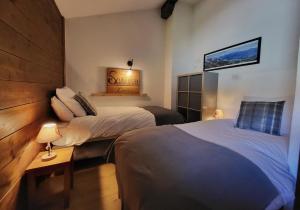 a hotel room with two beds and a table with a lamp at Cascades, 3 bedroom chalet with shared pool. in Samoëns +50 photos