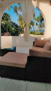 a room with two beds and a view of the beach at Watamu House in Watamu