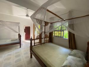 a bedroom with two bunk beds and a window at Watamu House in Watamu +2 photos