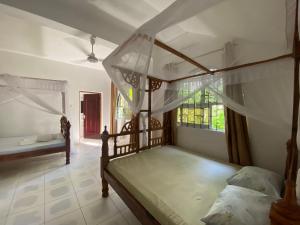 a bedroom with two bunk beds and a window at Watamu House in Watamu