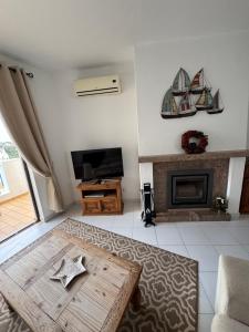 a living room with a table and a fireplace at Casa Julio in Carvoeiro