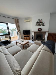 a living room with a large couch and a fireplace at Casa Julio in Carvoeiro