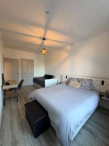 a bedroom with a large white bed and a desk at Appartement hyper-centre Épinal in Épinal