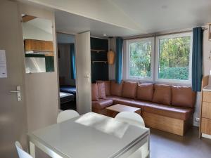 een woonkamer met een bank en een tafel bij Vacances en Mobil home 3 chambres à Piriac sur mer in Piriac-sur-Mer
