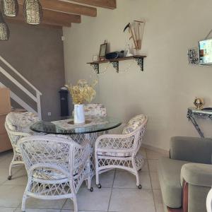 a dining room with a glass table and chairs at Au petit chai des Morinauds in Brives-sur-Charente +4 photos