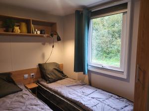 een kleine kamer met een bank en een raam bij Vacances en Mobil home 3 chambres à Piriac sur mer in Piriac-sur-Mer