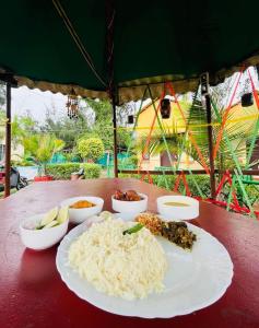 une assiette de riz et d'autres aliments sur une table dans l'établissement Resort Green Earth, à Tajpur 9 autres photos