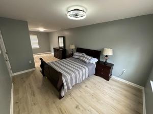 una camera da letto con un letto con una coperta a righe e pavimenti in legno di Spacious, Stylish and Luxurious a Brandywine