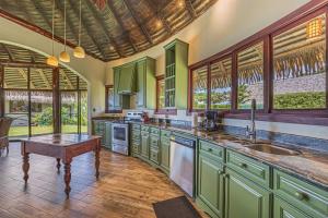 a large kitchen with green cabinets and a table at TikiVibez in Coronado