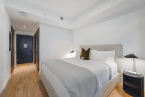 a bedroom with a white bed with a cat sitting on it at MVR Miami s Top Stay Views for Days in Miami