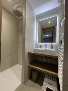 a bathroom with a sink and a mirror at Appartement Haut de Gamme neuf avec terrasse - 6 personnes - App 103 in Saint-Sorlin-dʼArves +9 photos