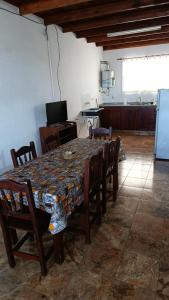 a dining room with a table with chairs and a refrigerator at Casa cdelu 2 habitaciones in Concepción del Uruguay