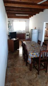 a dining room with a table and chairs and a kitchen at Casa cdelu 2 habitaciones in Concepción del Uruguay