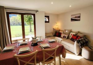 a living room with a table and a couch at Cascades, 3 bedroom chalet with shared pool. in Samoëns